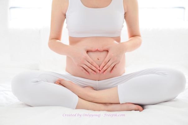Pre-natal exercises. Beautiful pregnant woman exercising while sitting in lotus position